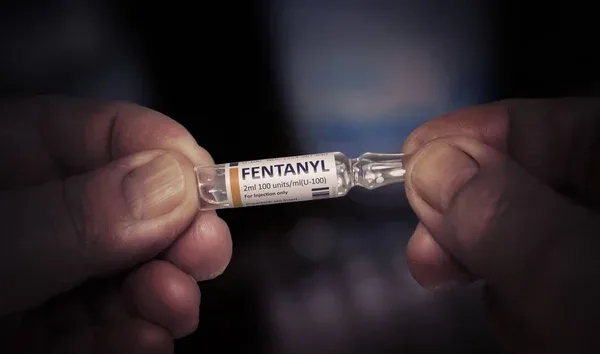 hands holding a vial of fentanyl
