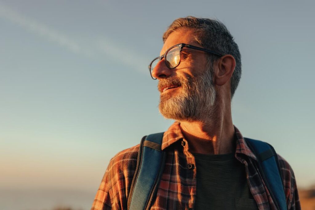 Man standing proudly in the sun, enjoying life after rehab