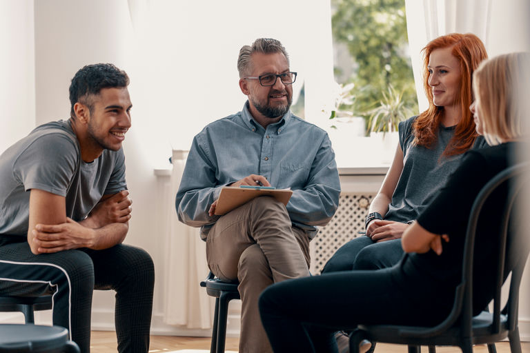 A group therapy session discussing five benefits of substance abuse treatment for recovery support