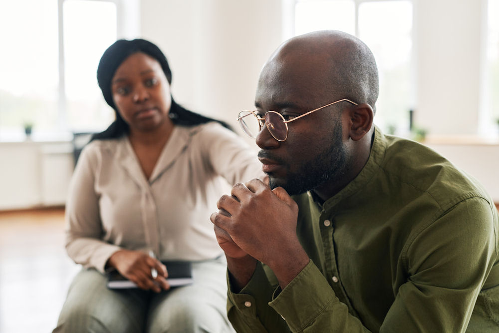 Man being comforted during CBT for alcohol use disorder
