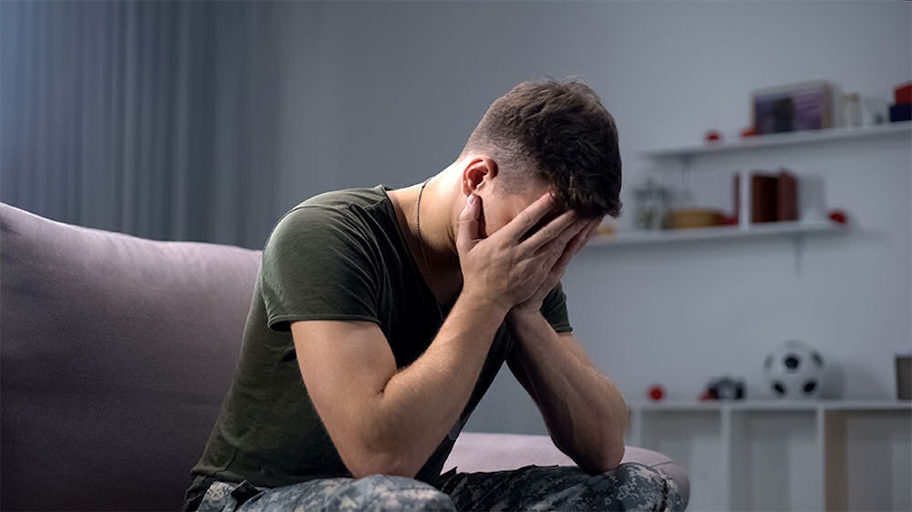 ptsd-night-terrors a veteran with face in hands in therapy
