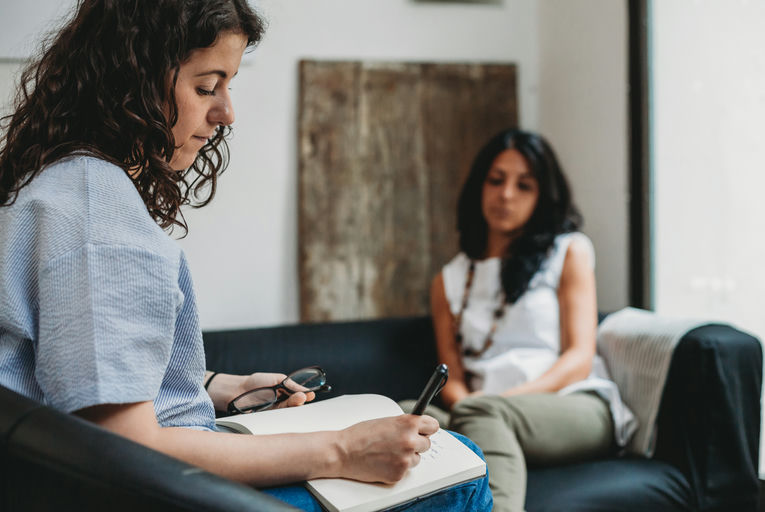 Woman in a recovery support group discussing challenges faced during addiction recovery
