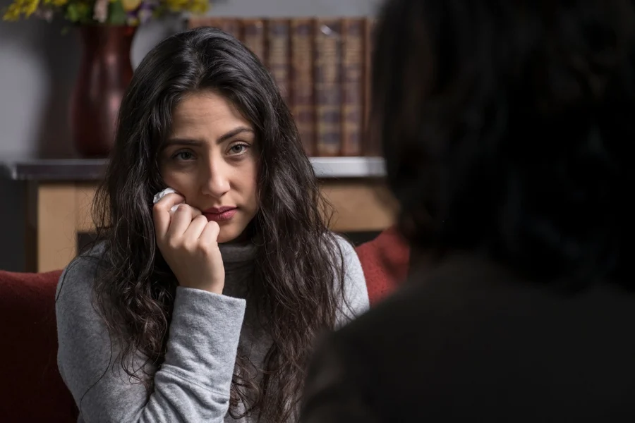 girl with anxiety disorder sitting in front of psychiatrist in rehab